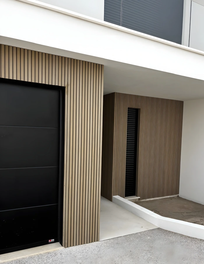 projeto mideia seixo vilas com revestimento tarimatec entrada da casa com garagem revestida a madeira ripada