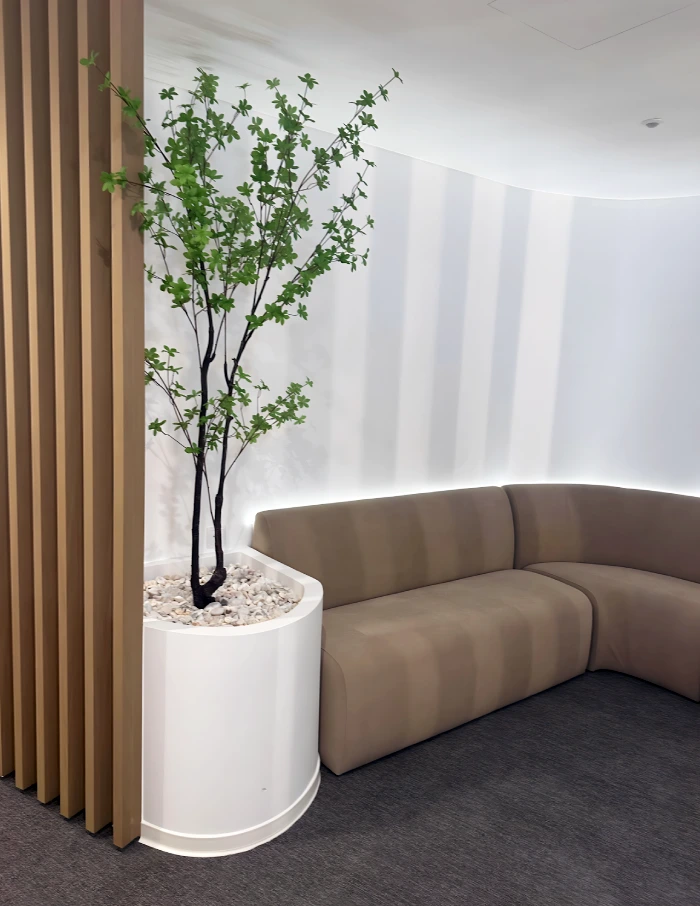 sala de estar com vaso e sofa da clinica Physioclem com pavimentos ntgrate e lico iberica e revestimentos tarimatec
